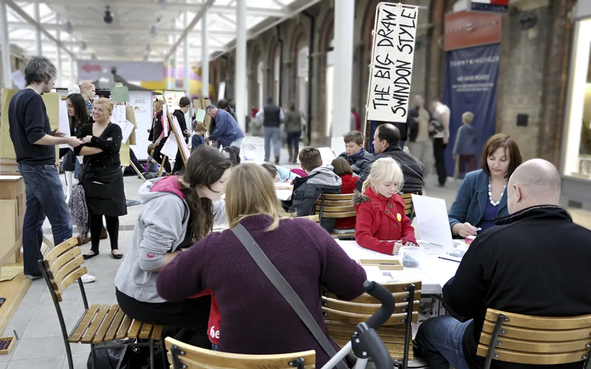photo taken in the large main entrance area at McArthurGlen, Swindon showing families taking part in drawing activities – Big Draw Swindon part of the Campaign for Drawing